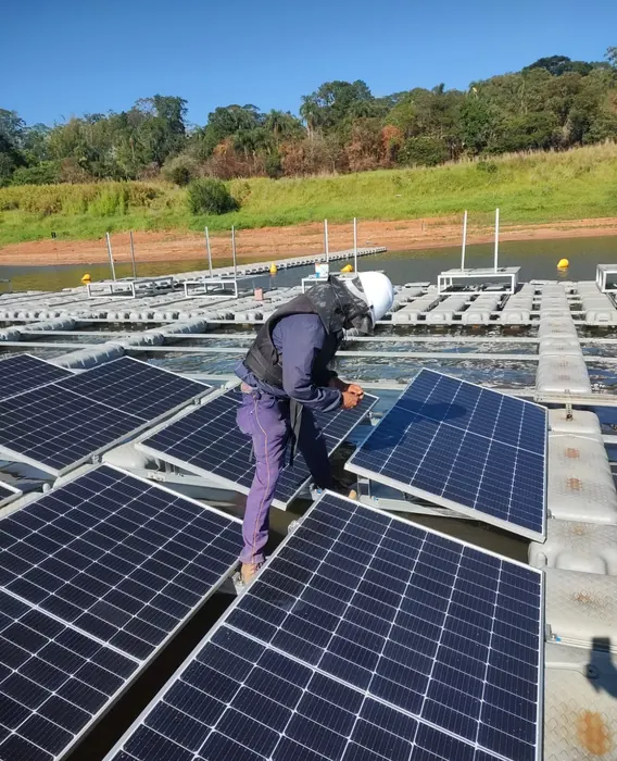 Profissional instalando módulos em usina solar flutuante